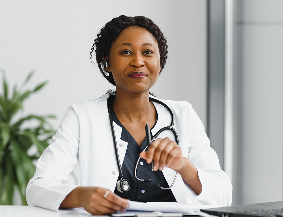 medicine, online service and healthcare concept - happy smiling african american female doctor or nurse with headset and laptop having conference or video call at hospital